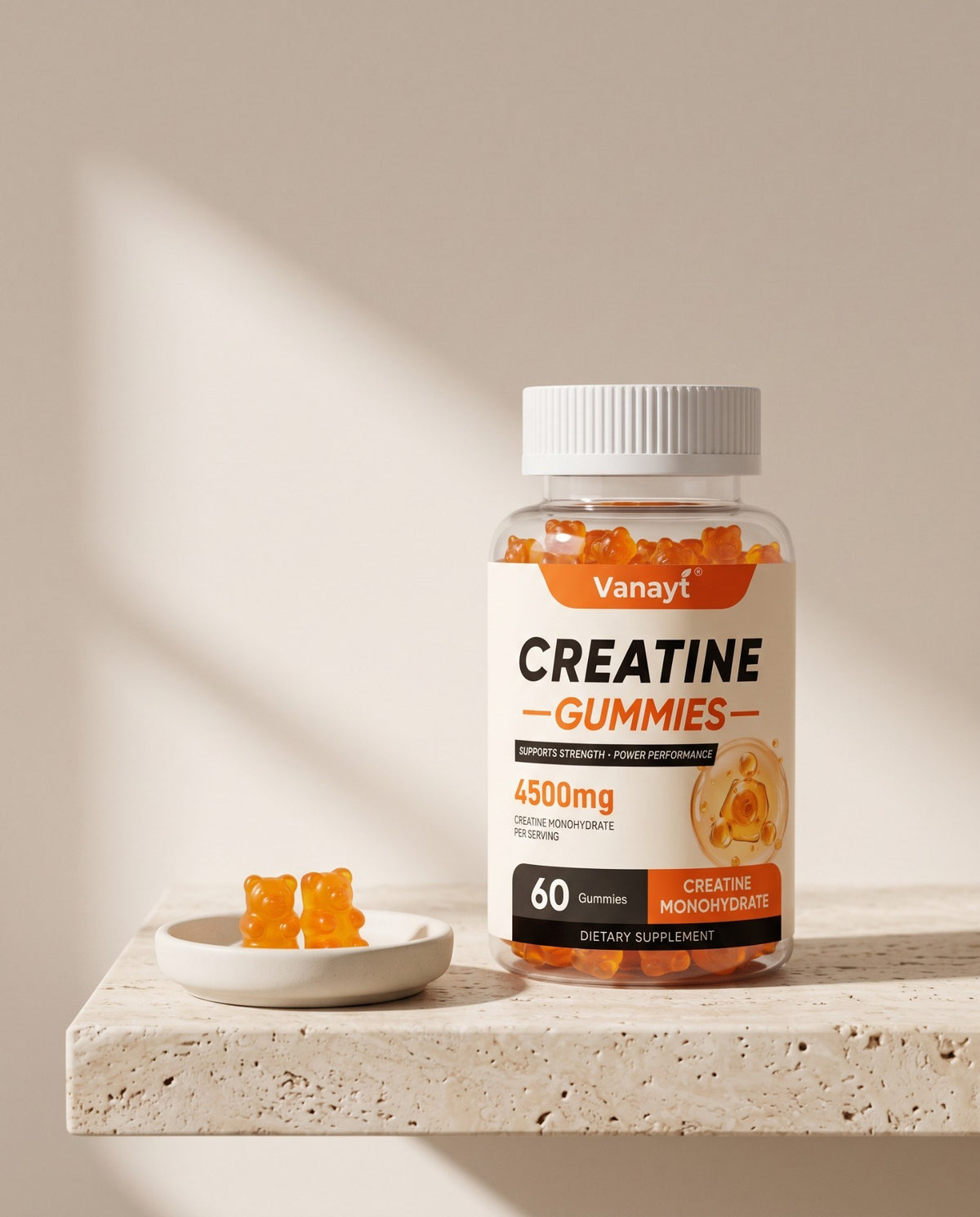 Vanayt creatine gummies bottle on a stone ledge beside two orange gummies in morning light