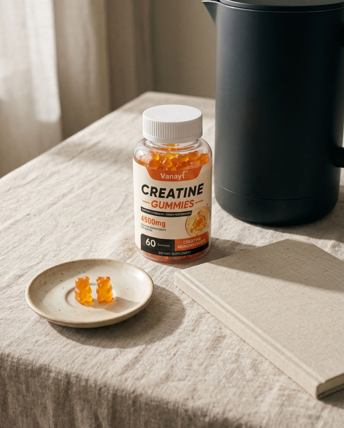 Creatine gummies bottle on a linen-covered table beside a coffee maker